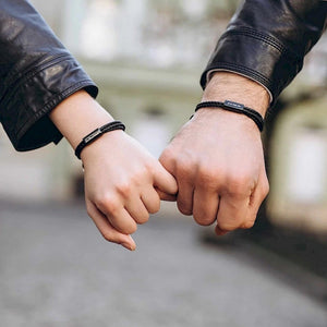 Two pairs of hands holding each other with blurred background