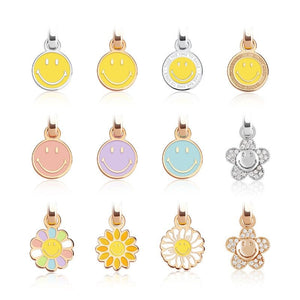 Set of colorful smiley face and flower-shaped pendants on a white background