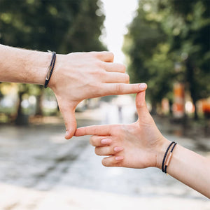 Two hands making a frame gesture with blurred greenery in the background