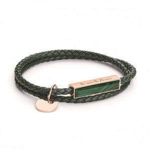 Green braided bracelet with a rose gold tag and heart charm on a white background