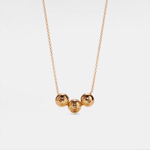 A gold-plated sterling silver pendant necklace with three spherical charms on a chain, displayed against a white background.