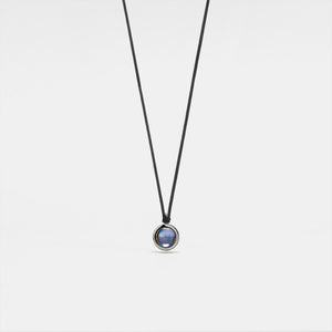 A black rope necklace with a circular silver pendant featuring a photo projection.