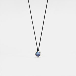 A black rope necklace with a circular silver pendant featuring a photo projection.
