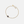 Gold bracelet with a dark gemstone on a light gray background