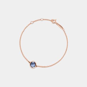 Rose gold bracelet with a projection gemstone on a light gray background