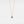 Rose gold necklace with a projection gemstone pendant on a light gray background