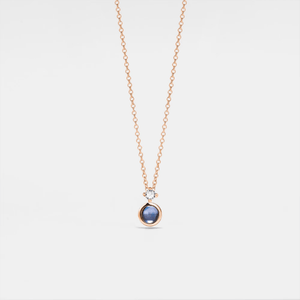 Rose gold necklace with a projection gemstone pendant on a light gray background