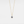 Gold necklace with a projection gemstone pendant on a light gray background