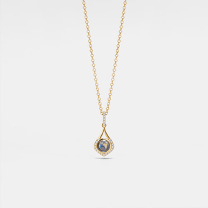 A gold-plated sterling silver charm necklace with a teardrop-shaped pendant featuring a photo projection, suspended from a delicate chain.