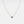 Gold necklace with a blue gemstone on a light gray background