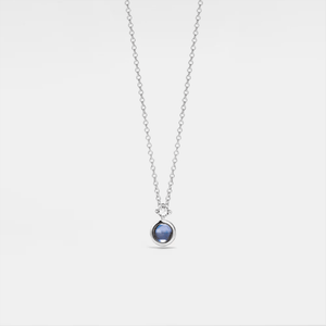Silver necklace with a projection gemstone pendant on a light gray background