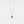 Gold necklace with a blue gemstone pendant on a light gray background