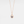A rose gold-plated necklace with a teardrop-shaped charm featuring a projection bead and small clear stones around the edge, on a white background.