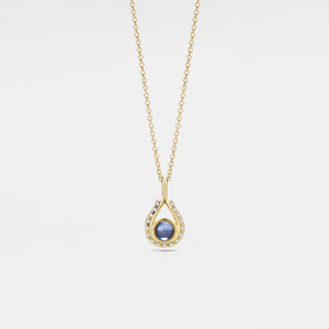 A gold-plated necklace with a teardrop-shaped charm featuring a projection bead and small clear stones around the edge, on a white background.