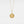 Gold necklace with a round locket pendant on a light gray background