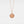 Rose gold necklace with a round locket pendant on a light gray background