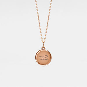 Rose gold necklace with a round locket pendant on a light gray background