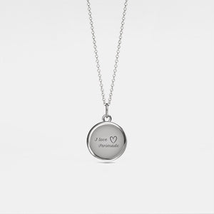 Silver necklace with a round locket pendant on a light gray background