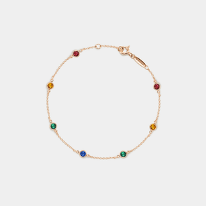 Gold bracelet with colorful gemstones on a white background
