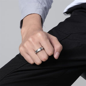 Model wearing a silver spinner rings with star designs on a gray background