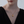 Woman wearing a gold heart-shaped locket necklace with a star and diamond on a light gray background