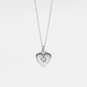 Silver heart-shaped locket necklace with a star and diamond on a light gray background