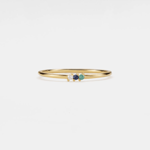 Gold ring with three gemstones on a white background