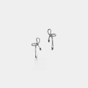Pair of silver bow-shaped earrings on a light gray background