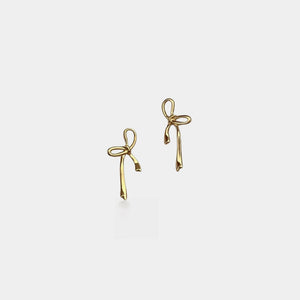 Gold bow-shaped earrings on a light gray background