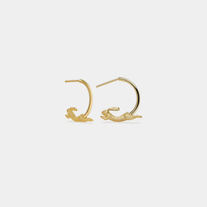 Gold hoop earrings with wave designs on a white background