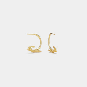 Gold hoop earrings on a light gray background