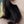 Close-up of an earring worn by a person with dark hair.