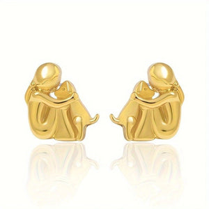 Gold earrings shaped like a couple embracing on a white background