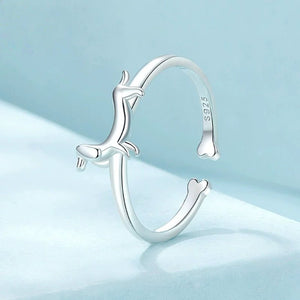 Silver ring with a dachshund dog design on a blue background