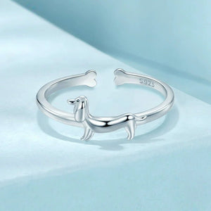 Silver ring with a dachshund dog design on a blue background