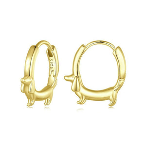 Gold hoop earrings with a dog design on a white background