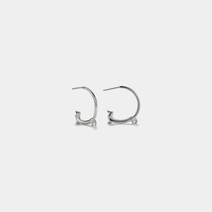 Pair of silver hoop earrings on a light gray background