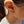 Close-up of an ear wearing a hoop earring with a cross pendant.
