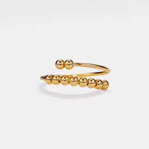 Gold beaded bracelet on a light gray background