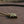 Gold necklace with a green gemstone pendant on a wooden surface