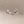 Pair of silver ginkgo leaf earrings on a beige background