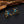 Gold bee-shaped earrings with blue gemstones on a dark surface