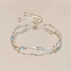 Silver bracelet with blue accents on a beige background