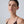Woman wearing a black strappy top against a plain background