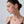 Woman wearing a delicate earring on a plain background