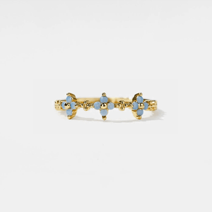 Gold ring with blue floral designs on a white background