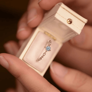 Jewelry box with a blue gemstone earring held by a hand
