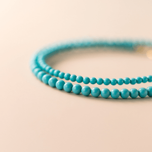 Turquoise beaded bracelets on a beige background