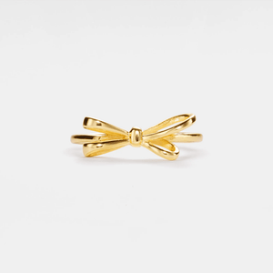 Gold bow-shaped ring on a white background