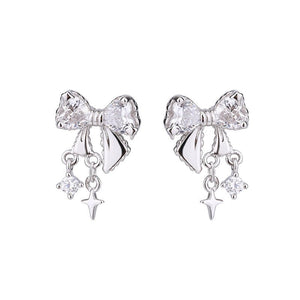 Silver bow-shaped earrings with star charms on a white background